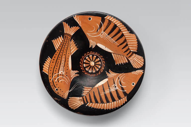 Un piatto di ceramica con raffigurazioni di pesci