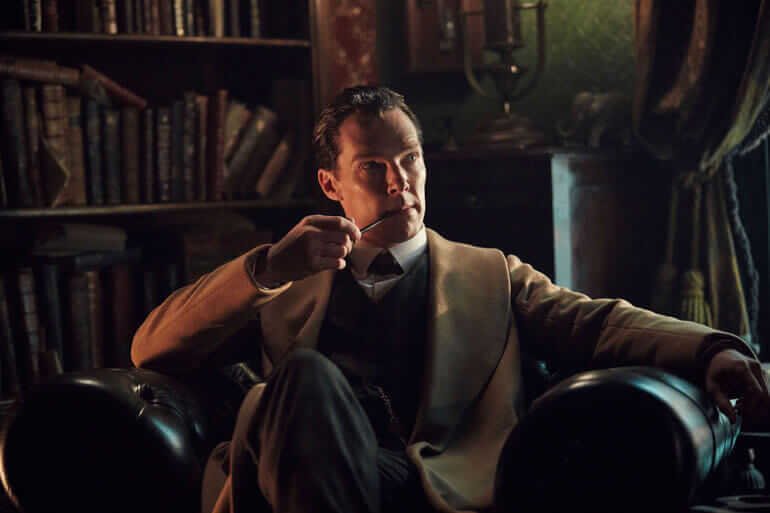 Benedict Cumberbatch nel ruolo di Sherlock Holmes, seduto in poltrona